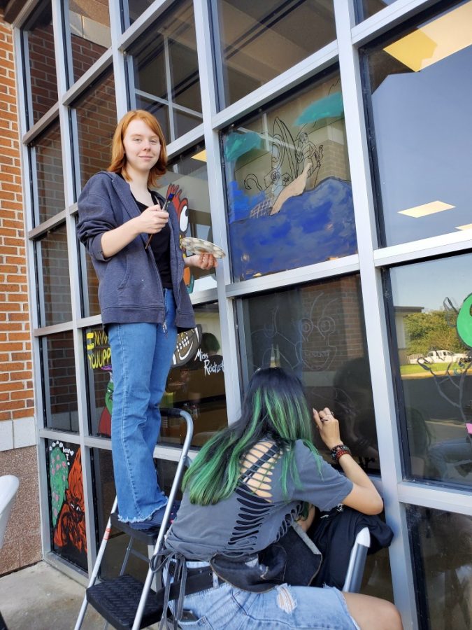 Addison Coleman  and Lilliana Quiroz are painting the windows of commons for homecoming week. They painted Moanas boat.