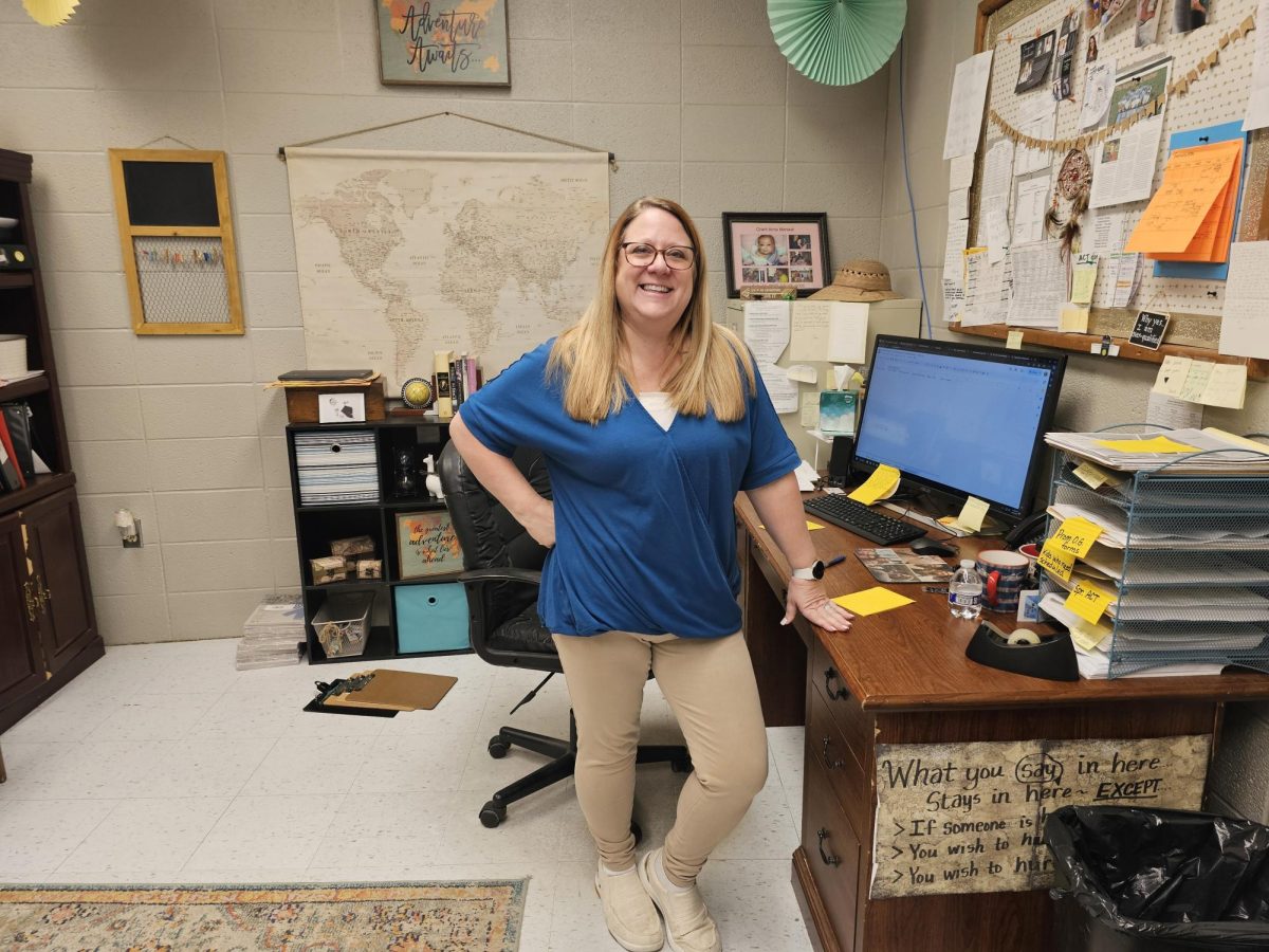 A photo of Mrs. Merseal standing in front of her desk.