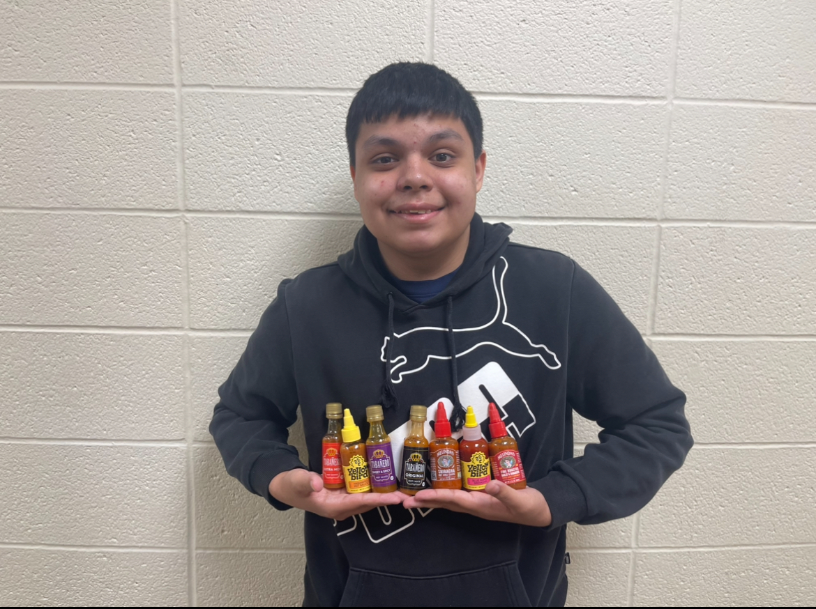 Jaren holding all the hot sauce they tried.