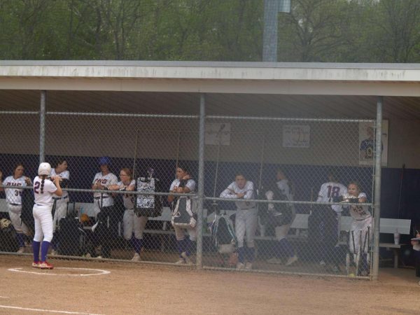 Trojans cheering on their teammate from the dugout. 
