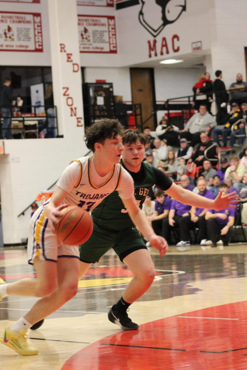 Sophomore Rhenn Mapes driving past a Ste Gen guard 